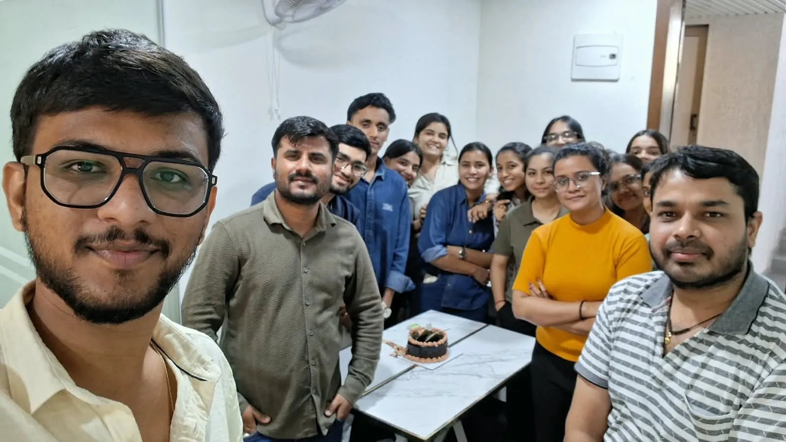 Bizyocon team members celebrating with a cake at the office