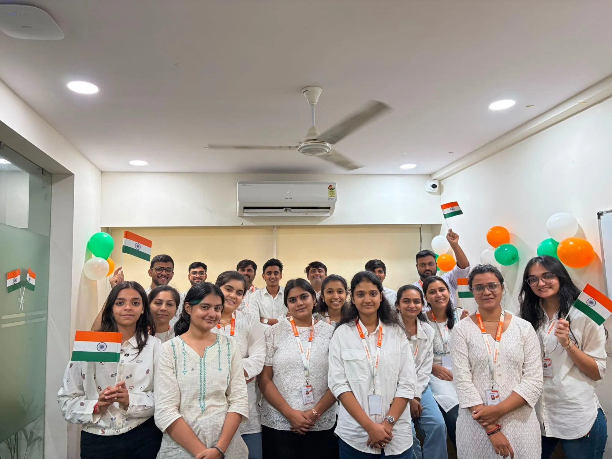 The Bizyocon team in white, holding Indian flags, at the Gandhinagar office