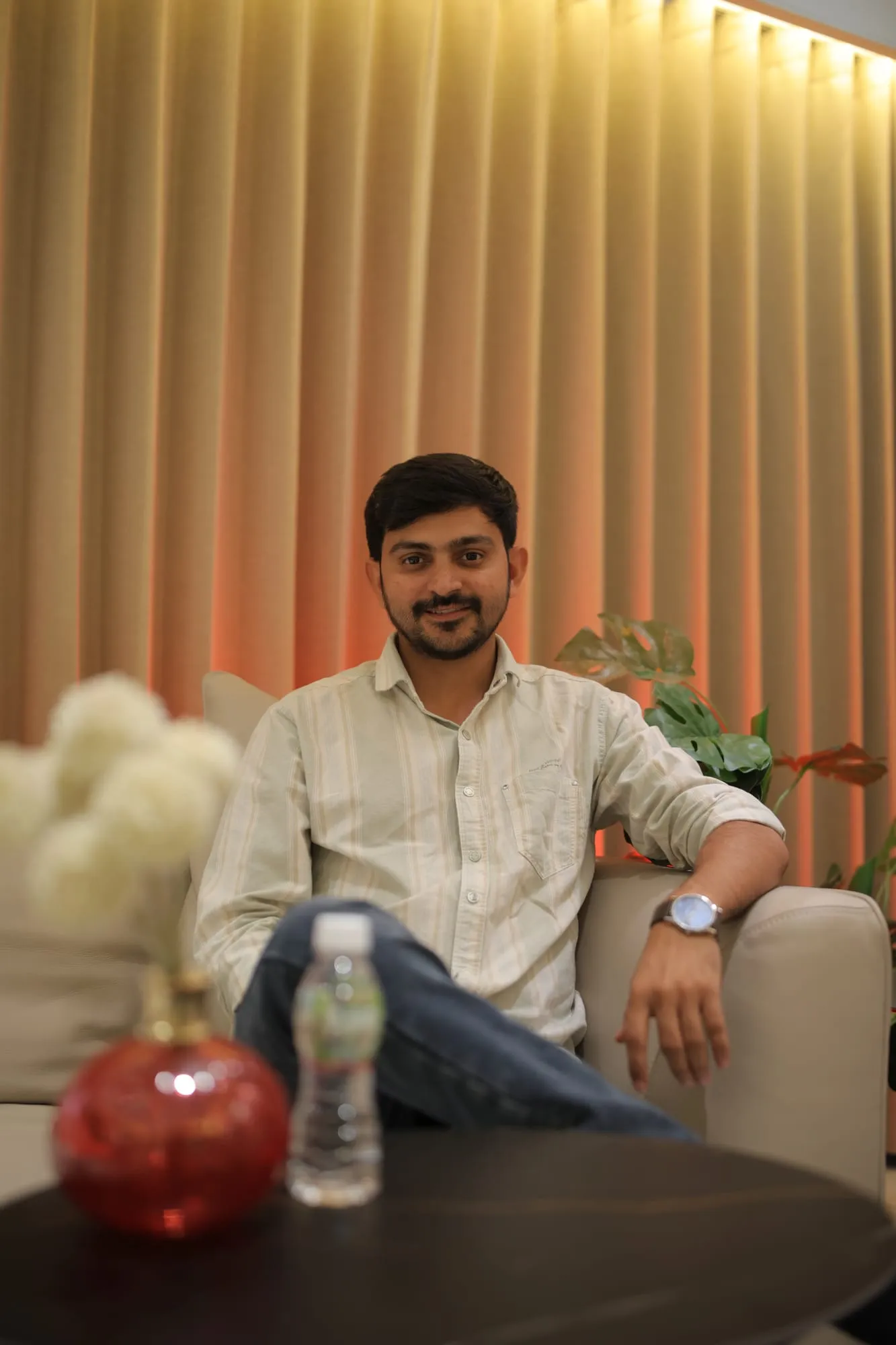 Mukesh Chaudhary beyond work Mukesh Chaudhary relaxing on a sofa in a casual shirt